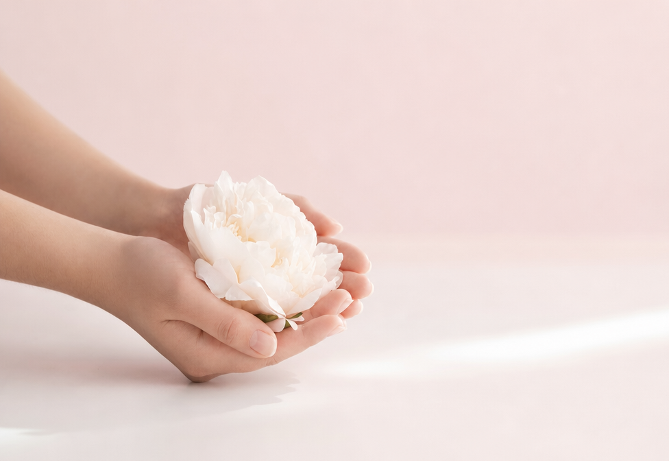 Manos sosteniendo una flor como imagen conceptual del bienestar femenino.